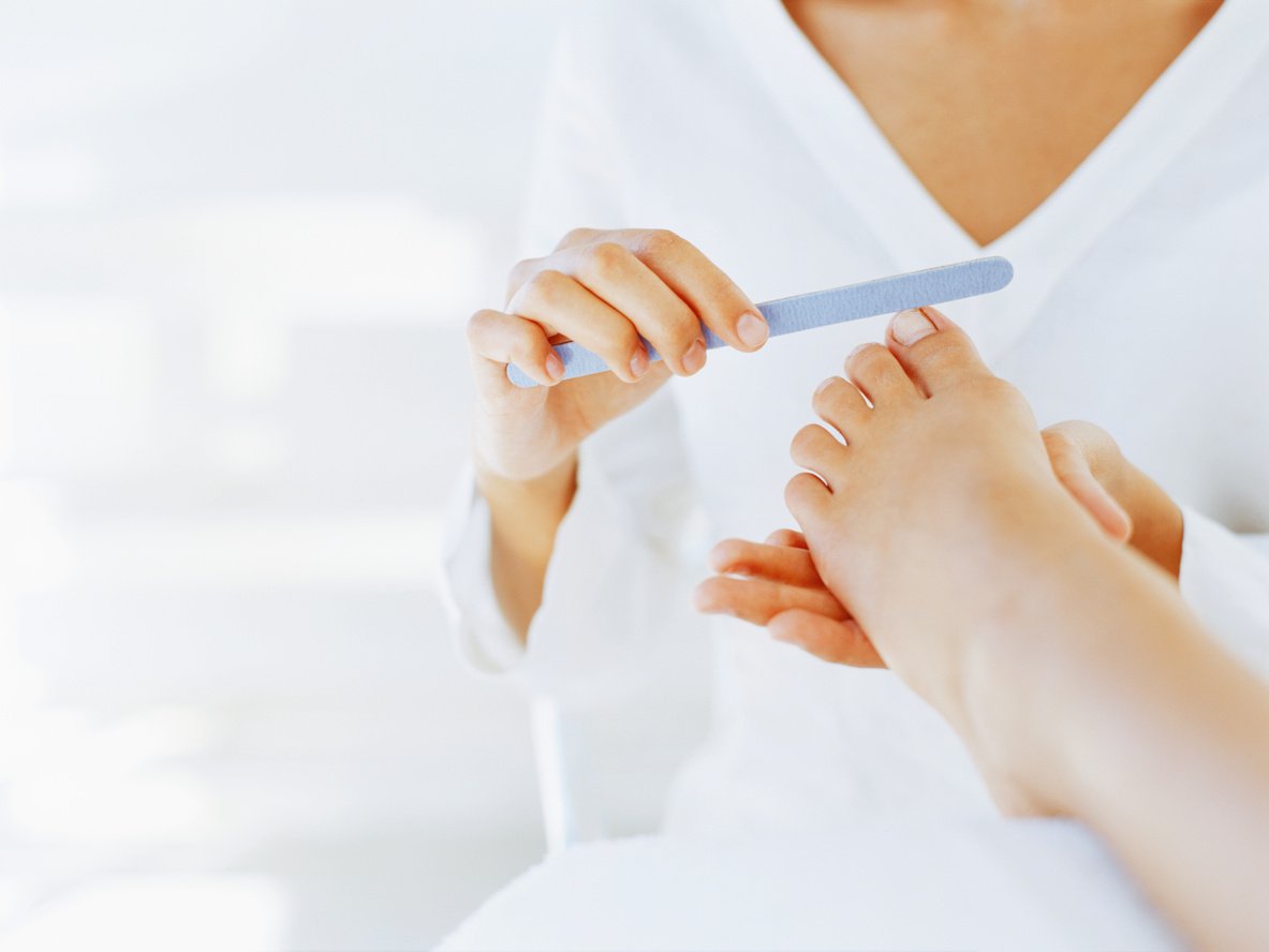 mid section view of a woman giving a pedicure